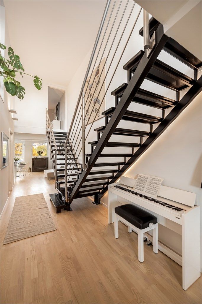 Innvendig trapp i stål og stein forbinder etasjene og slipper lyset gjennom rommene. Trappen fremstår som et naturlig blikkfang i boligen.