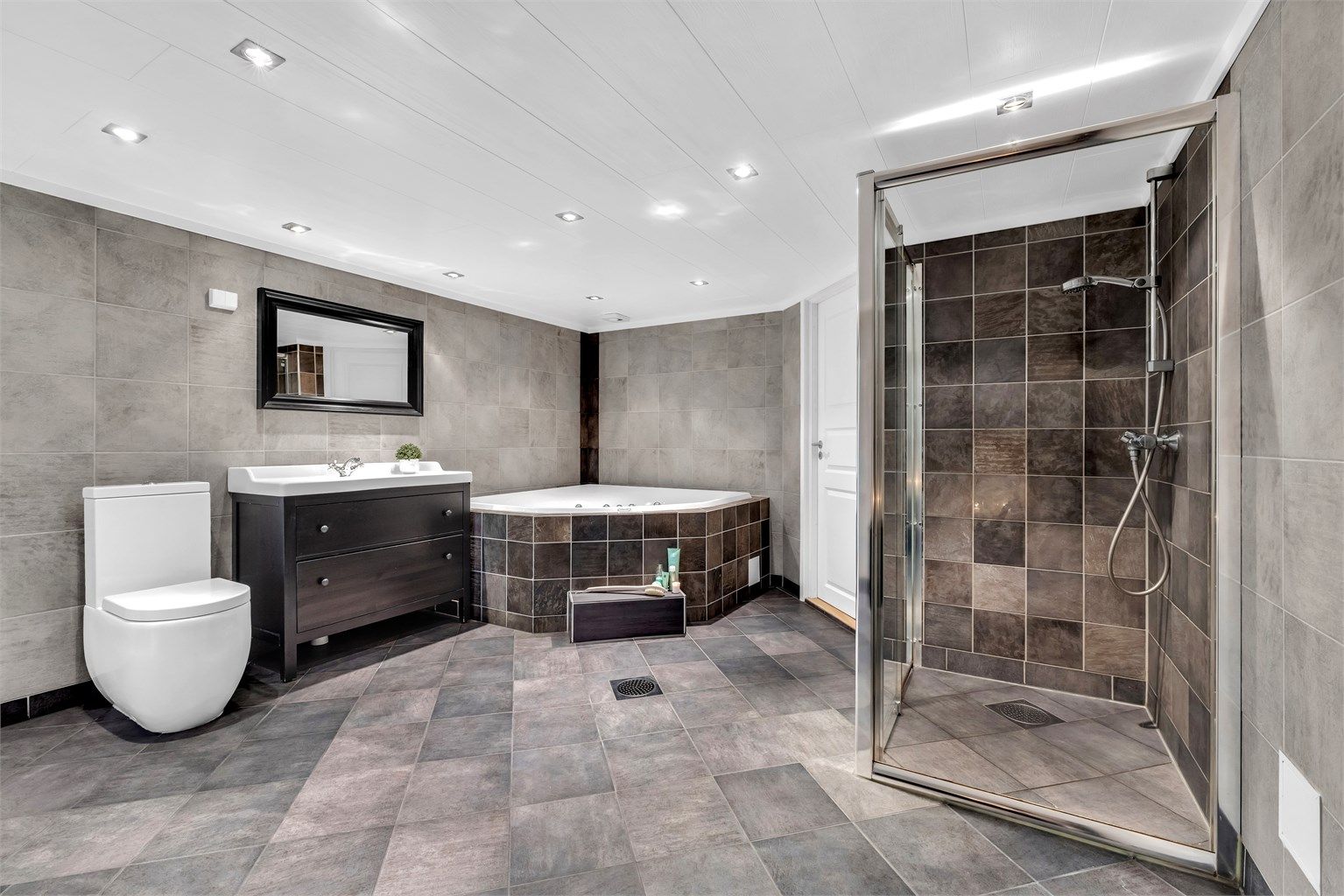 Baderommet i kjelleren ble ifølge selger pusset opp i 2008 og har fliser med gulvvarme, samt downlights i taket. Badet har et stort innbydende  boblebadekar som er perfekt for både liten og stor