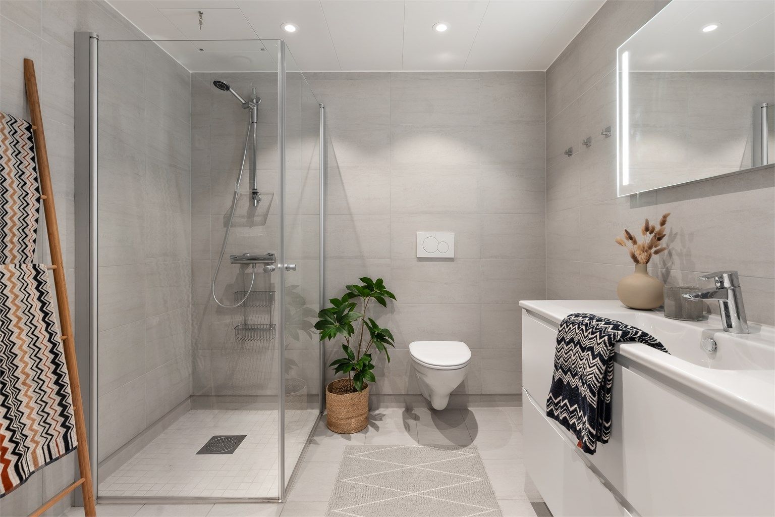 Bad fra byggeår. Flislagt gulv med gulvvarme og flislagte vegger. Platelagt himlingsflate med downlights.