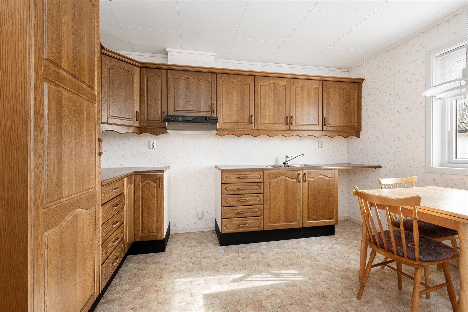 Kjøkkenet i hovedetasjen har innredning med profilerte fronter fra byggeåret og godt med skap- og benkeplass