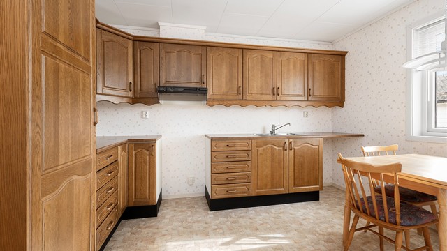 Kjøkkenet i hovedetasjen har innredning med profilerte fronter fra byggeåret og godt med skap- og benkeplass