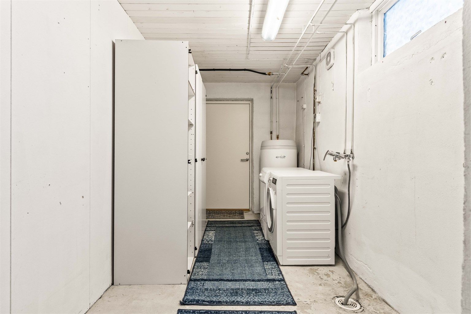 Praktisk vaskerom med gulvvarme, opplegg for vaskemaskin og egen utgang til hagen.