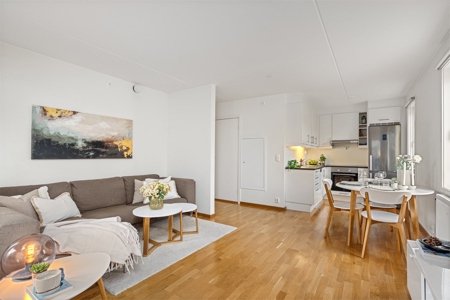 Åpen stue- og kjøkkenløsning med plass til både sofagruppe og spisebord.
