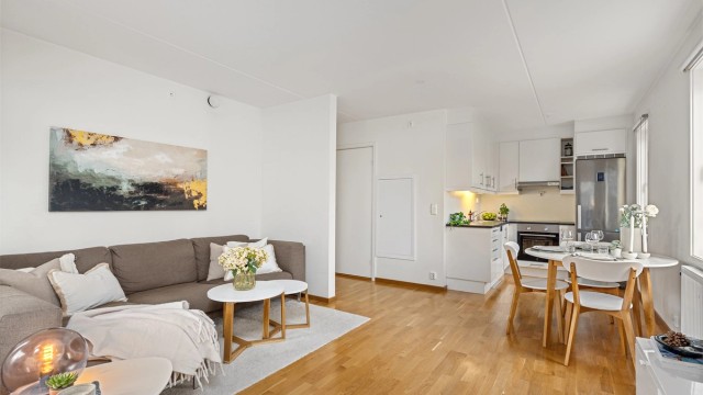 Åpen stue- og kjøkkenløsning med plass til både sofagruppe og spisebord.