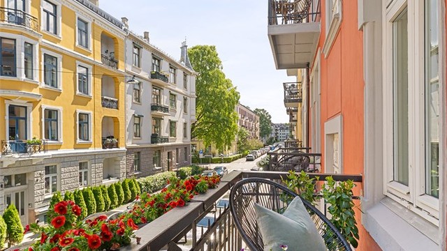 Balkongen vender mot gaten og har utsikt over den karakteristiske bygårdsbebyggelsen i Åsaveien, med plass til mindre sittegruppe og beplantning.