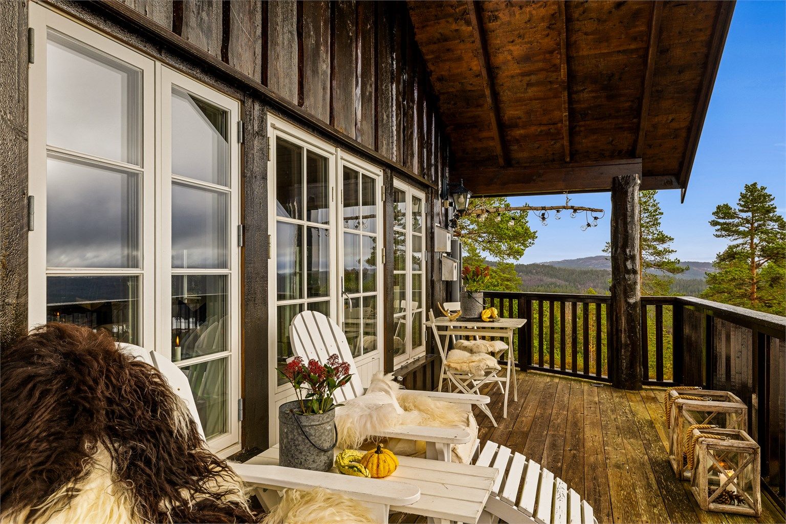 Takoverbygget gjør det enkelt å ha møbler stående ute hele året. Solide stokker som bærer overbygget gir hytta et barskt preg og står fint til kledningen.