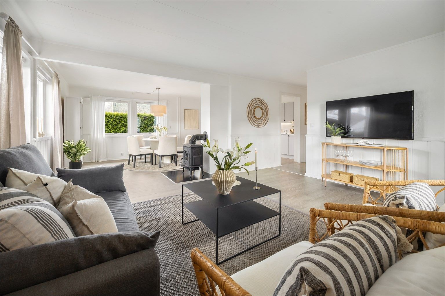 Den åpne løsningen mellom stue og kjøkken skaper en sosial og luftig sone i boligens første etasje.