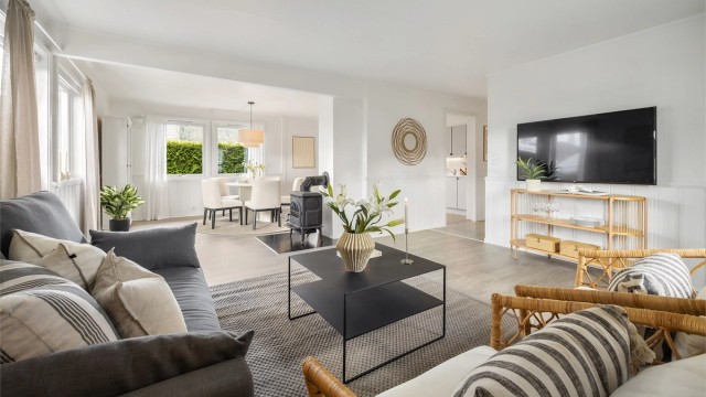 Den åpne løsningen mellom stue og kjøkken skaper en sosial og luftig sone i boligens første etasje.