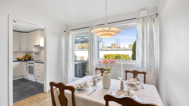 Fra spisestuen er det utsikt mot hagen og direkte utgang til den overbygde terrassen.
