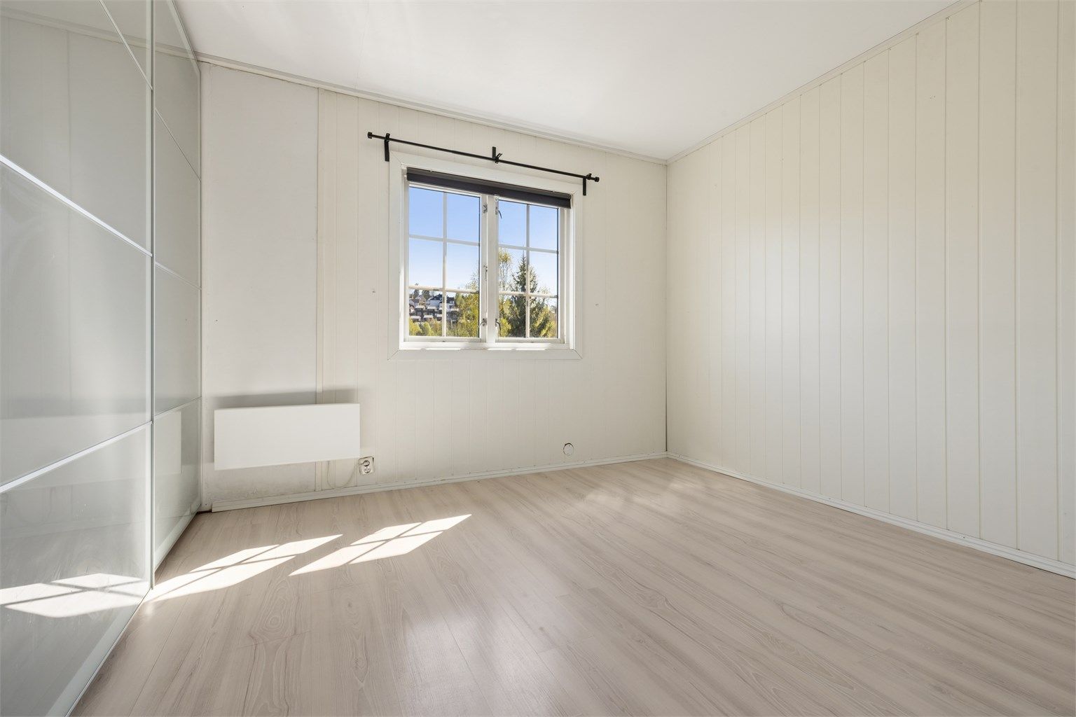 Soverom med skyvedørsgarderobe.