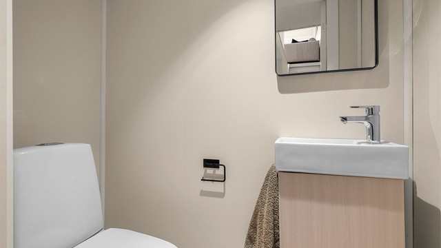 Praktisk separat wc på 1,5 kvm med servantskap med speil og toalett.