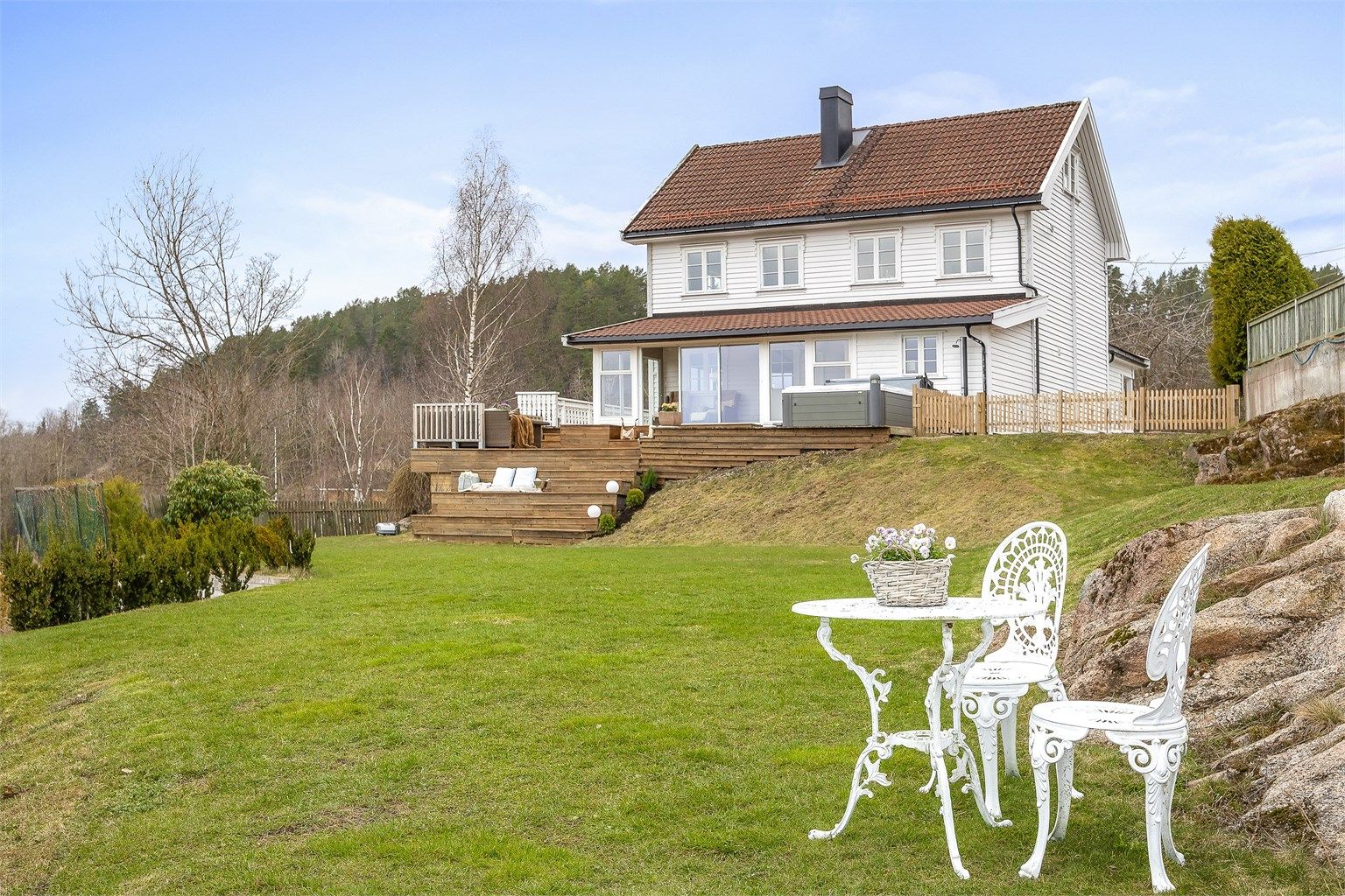 Eiendommen ligger høyt og fritt til i en skrånende tomt.