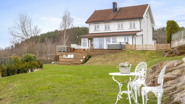 Eiendommen ligger høyt og fritt til i en skrånende tomt.