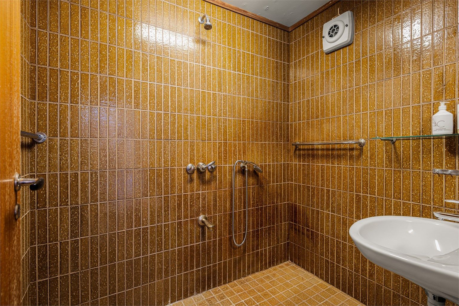 Badet i 1. etasje har også retrostil med karakteriske flis. Integrert dusjarmatur og servant.