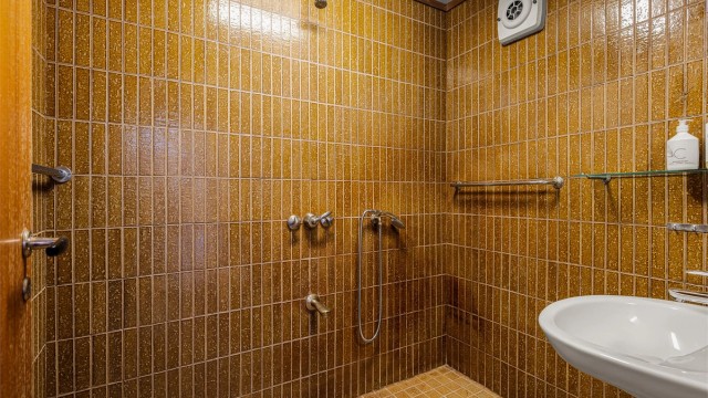Badet i 1. etasje har også retrostil med karakteriske flis. Integrert dusjarmatur og servant.