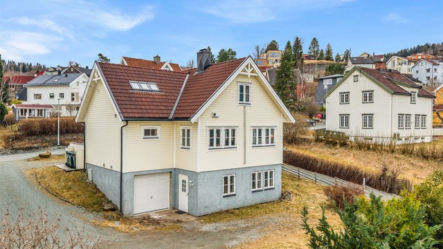 Her får du en flott enebolig over flere plan, med integrert garasje i underetasjen og en beliggenhet som gir både utsyn og privatliv.