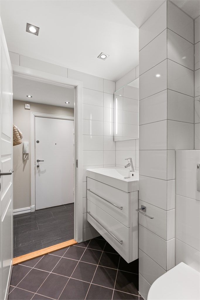 Innredningen består av en vegghengt servant med speil og sidelys, samt et vegghengt toalett.