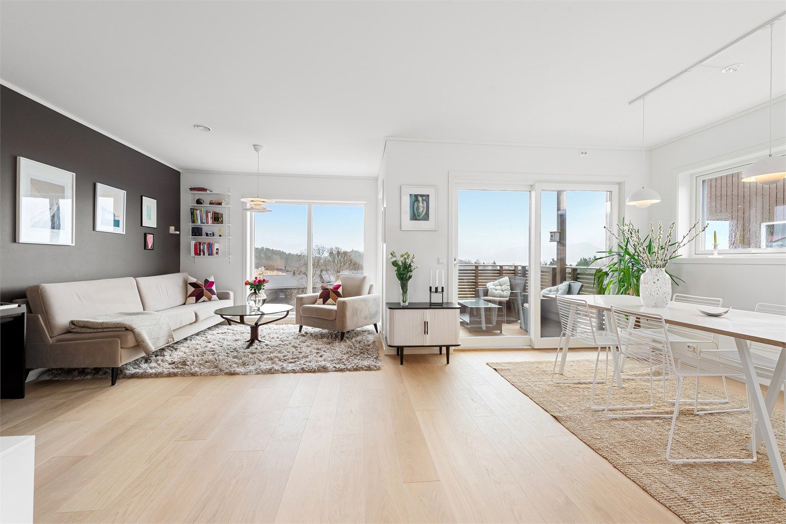 Hovedetasjens sosiale sone er lys og luftig, med god plass til både spisebord og sofagruppe