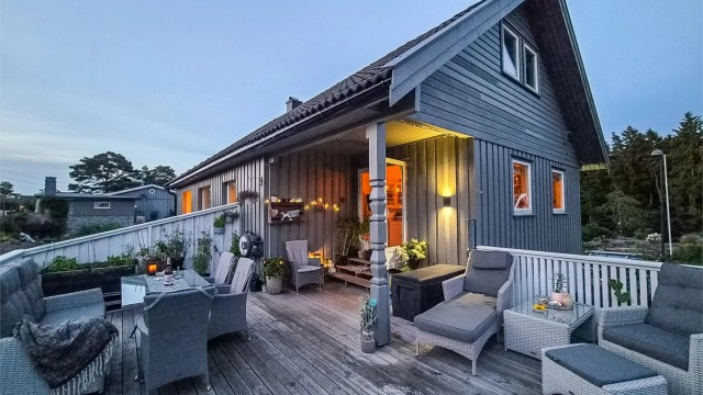 Terrassen blir en stemningsfull forlengelse av boligen på kveldstid.