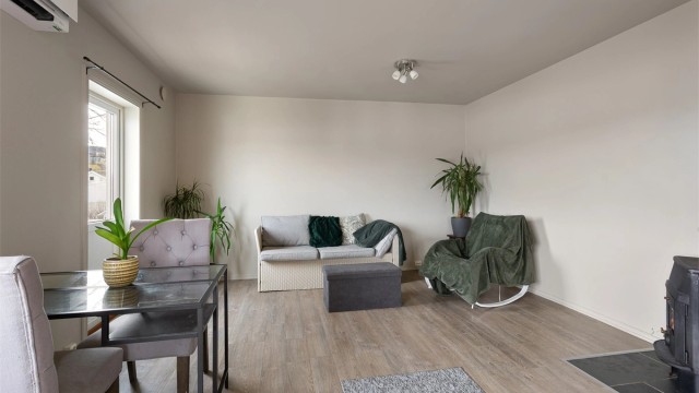 Rommet har gjennomgående laminat på gulvet, som gir en enhetlig og åpen romfølelse.