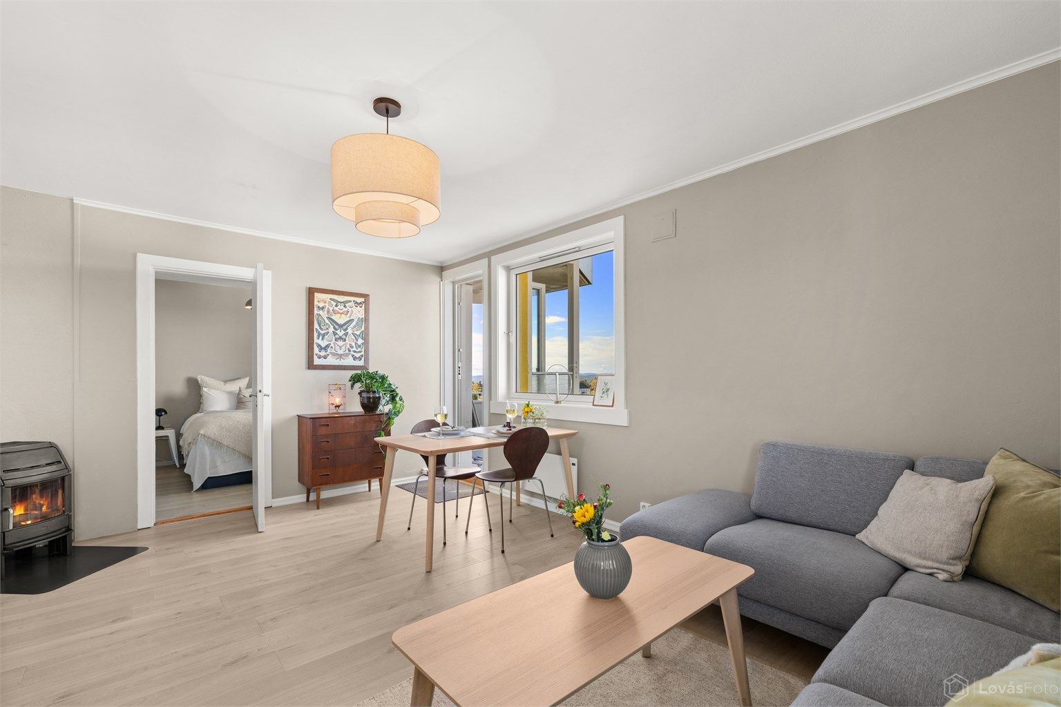 Den romslige stuen har plass til både spisebord og en komfortabel sofagruppe, mens peisovnen bidrar med både varme og ekstra hygge gjennom året.