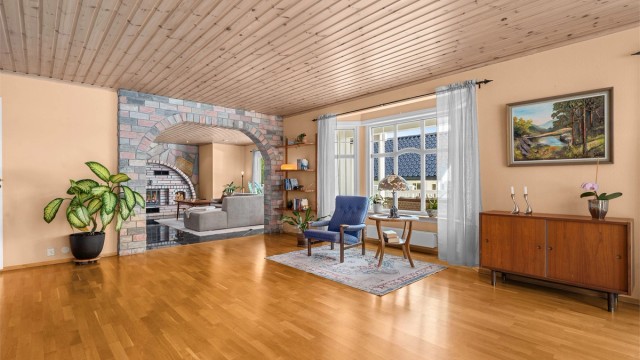 Stuen er romslig og gjennomgående, med parkett på gulvet og panel i taket.