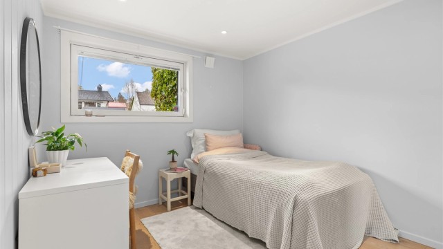 Romslig soverom med 1-stavs parkett på gulvet med vannbåren gulvvarme og downlights i himling