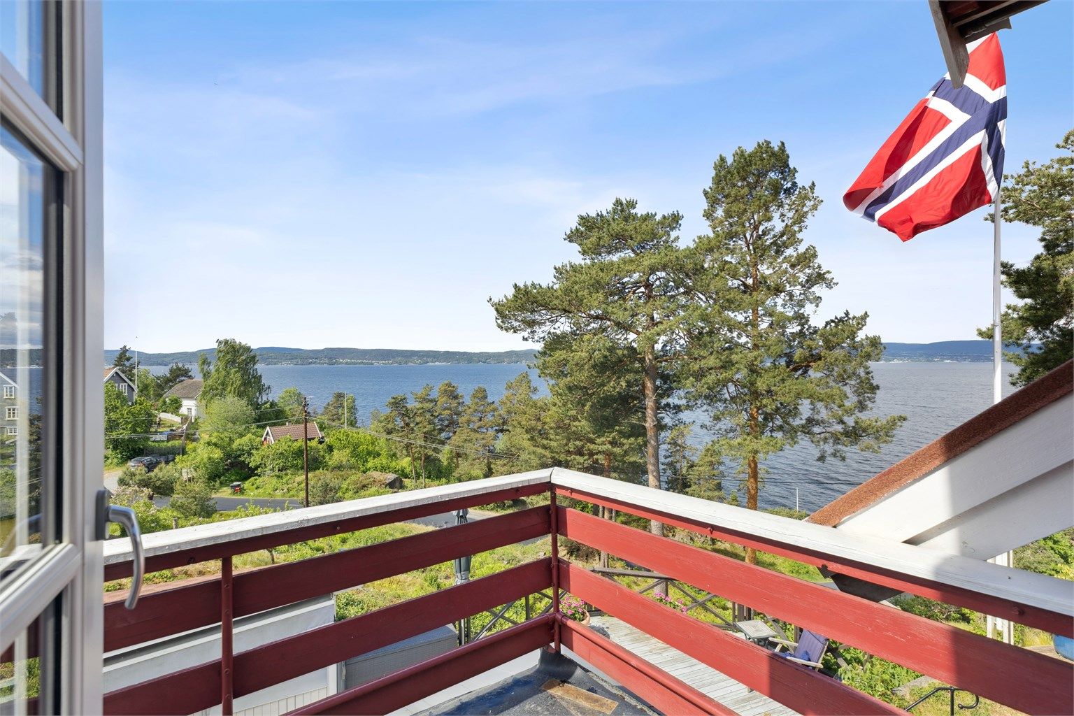 Utgang fra hovedsoverom til sydvestvendt balkong med vidstrakt utsikt mot fjorden