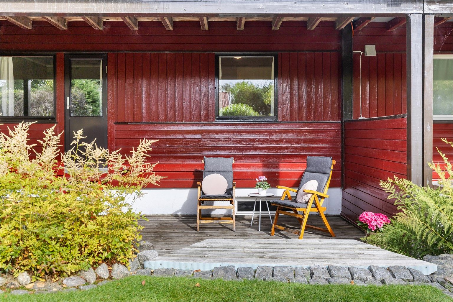 Overbygget platting som gir en lun og skjermet sitteplass.
