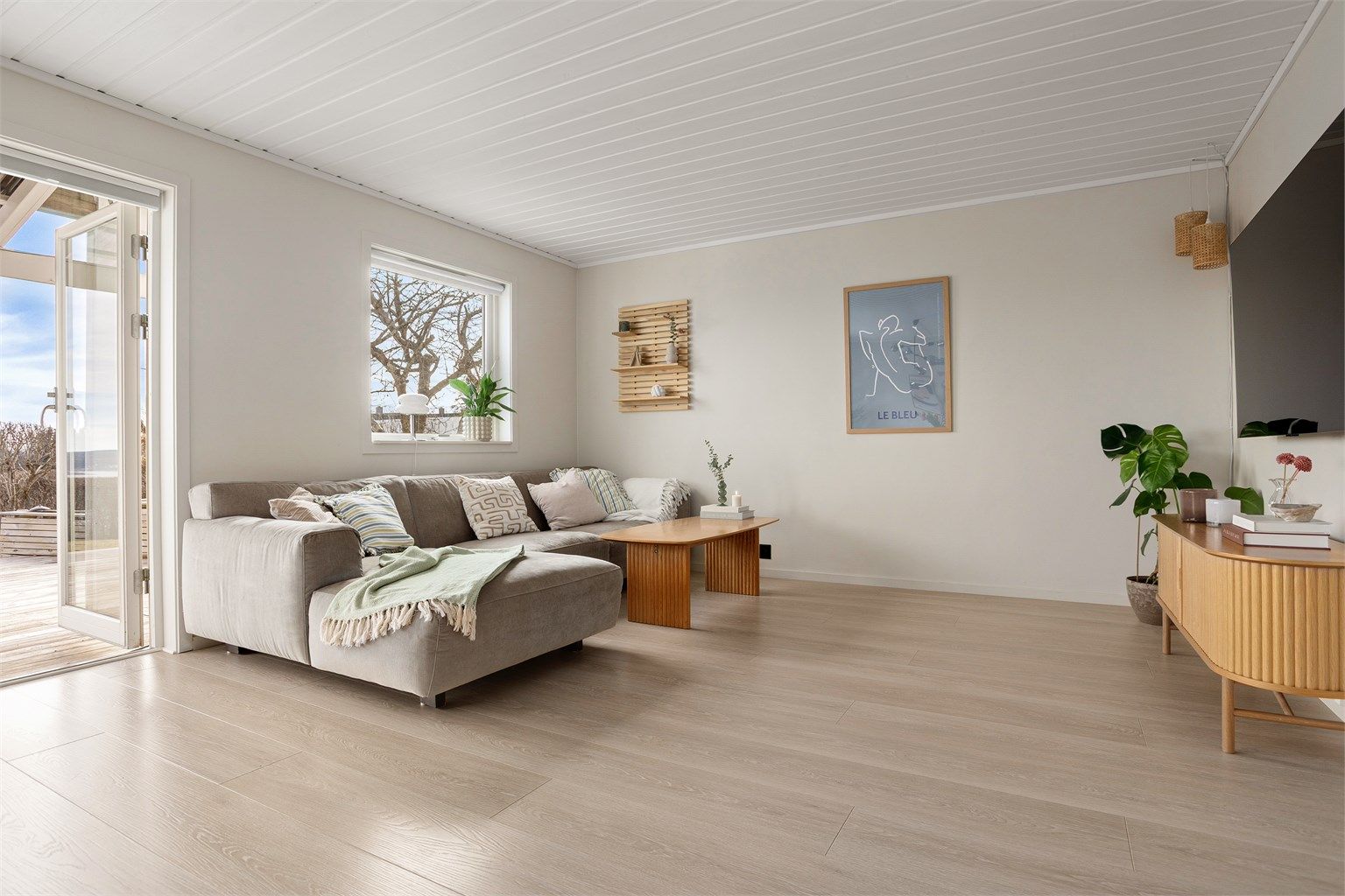 Stuen er malt opp i moderne farger og har god plass til sofahjørne med tilhørende møblementer og tv-seksjon