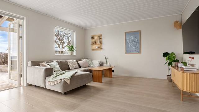 Stuen er malt opp i moderne farger og har god plass til sofahjørne med tilhørende møblementer og tv-seksjon