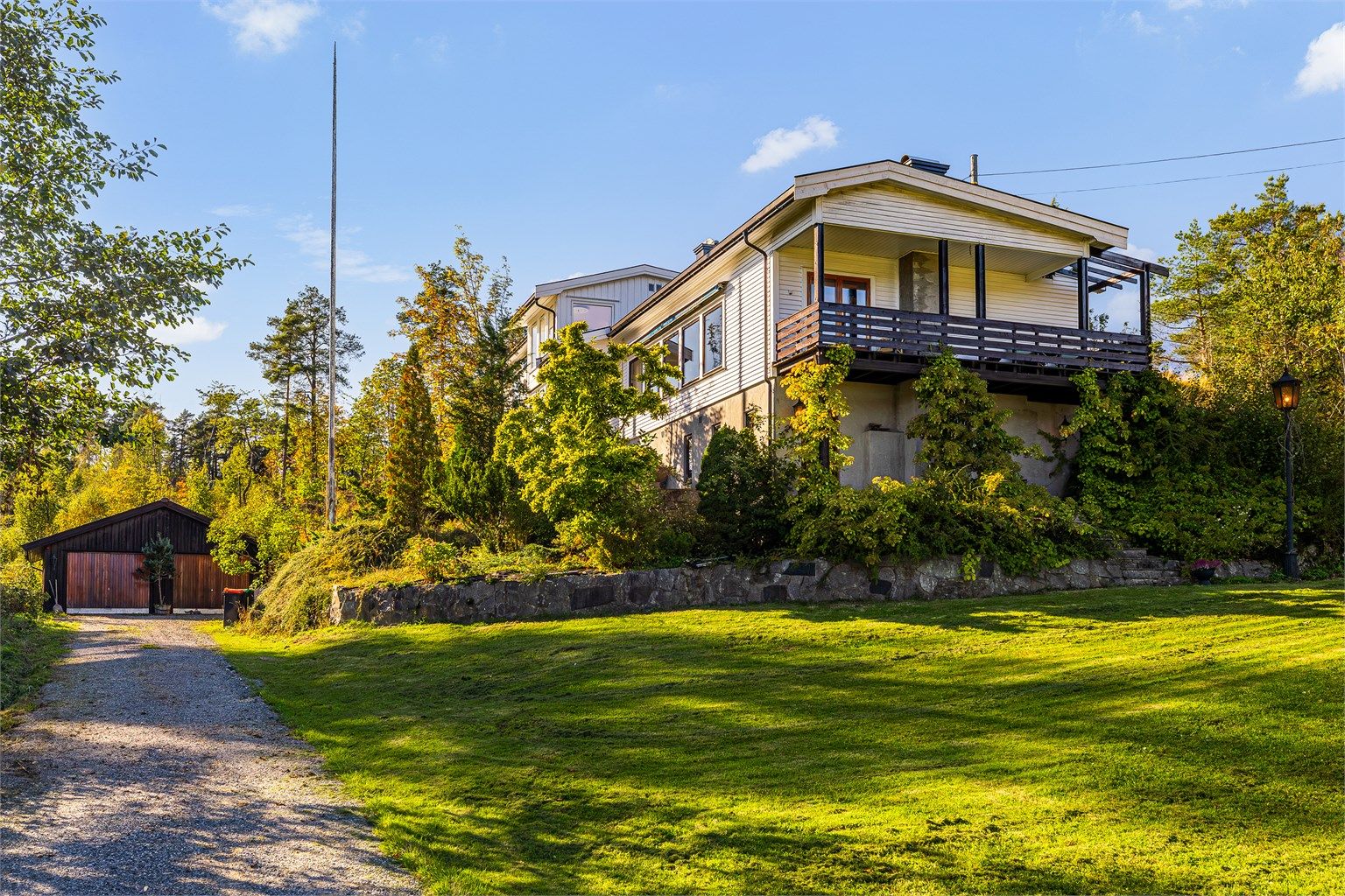 Huset ligger idyllisk til, omkranset av åkerlandskap og skog. Her er det stille, vakkert og fredelig. Panelet på gavlveggen er malt etter at bildet ble tatt.