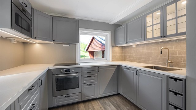 Innredningen har grå 1-speils fronter og en slitesterk laminatbenkeplate.