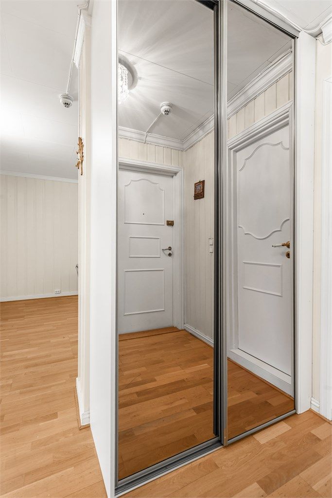 Praktisk skyvedørsgarderobe med speilfronter gir rikelig med oppbevaringsplass i gangen.