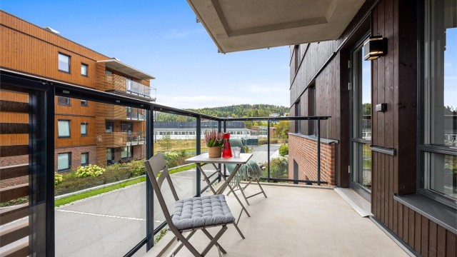 Balkongen har overbygg og utsyn mot fellesarealene.
