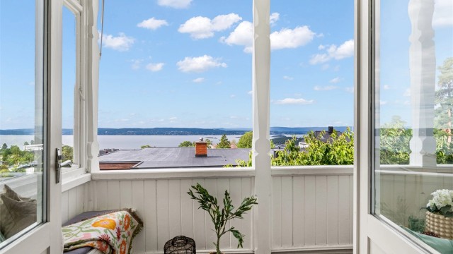 Fra både spisestuen og stuen er det via doble verandadører utgang til solrik og vestvendt veranda med vidstrakt utsikt mot fjorden