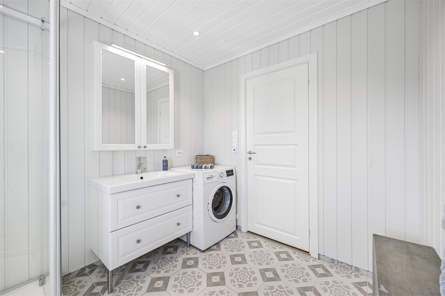 Badet har servantinnredning med speilskap og overlys. Her er også fordelerskapet for rør-i-rør-systemet plassert.