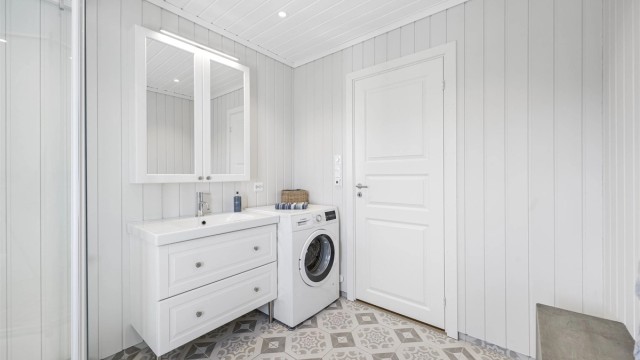 Badet har servantinnredning med speilskap og overlys. Her er også fordelerskapet for rør-i-rør-systemet plassert.