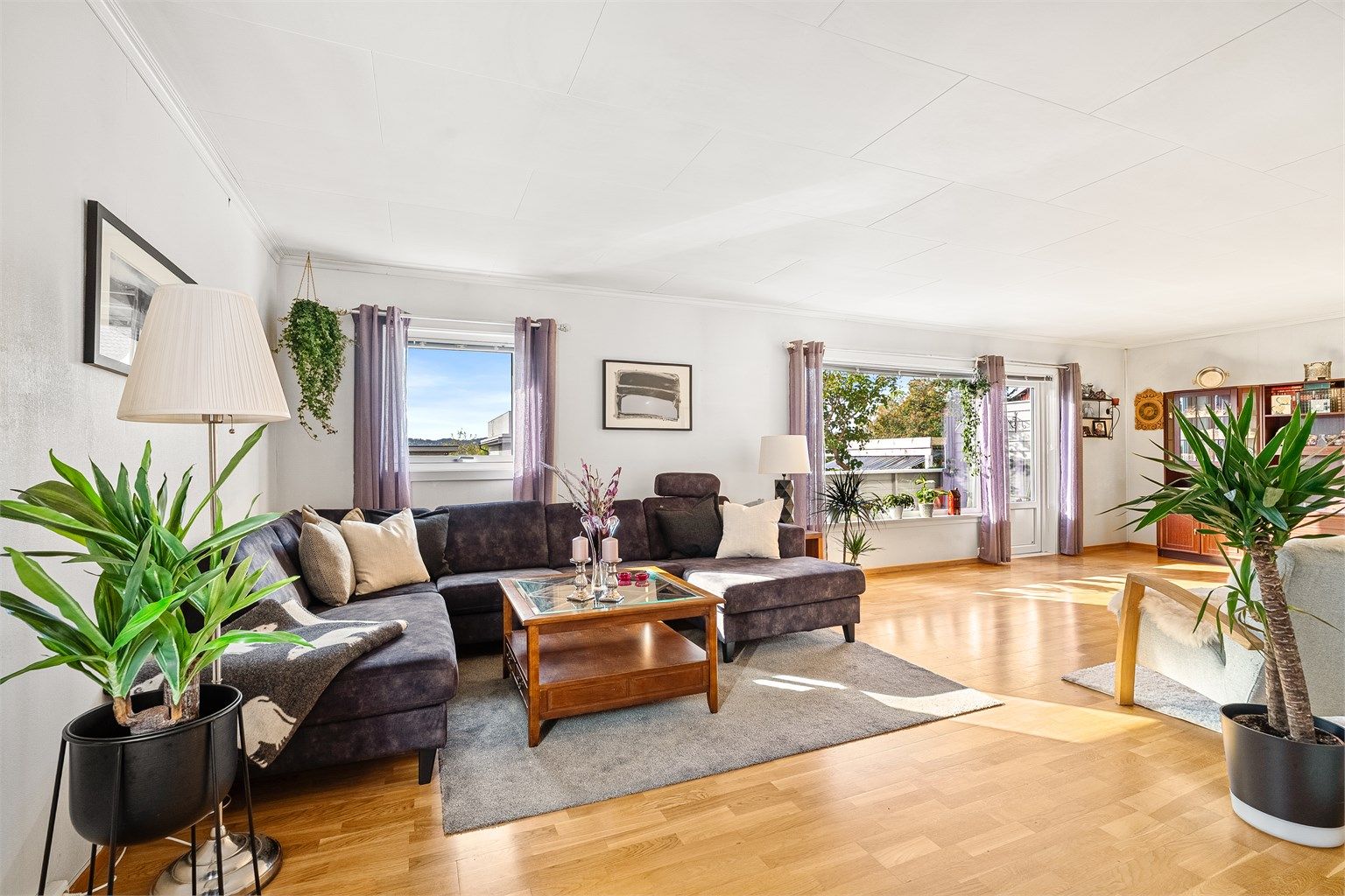 Lys og romslig stue med store vindusflater.