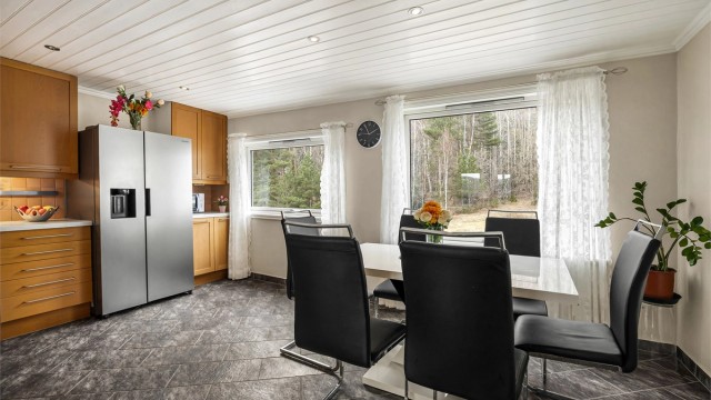 Kjøkkenet har flislagt gulv med gulvvarme og god plass til en egen spiseplass.