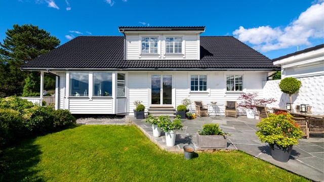 Eneboligen har impregnert, liggende bordkledning og takstein i betong.