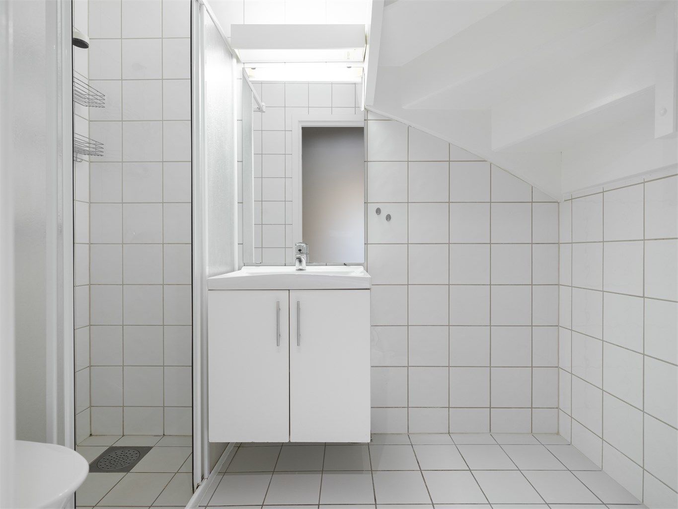 Tidløst flislagt bad med varme i gulv og opplegg for vaskemaskin. 