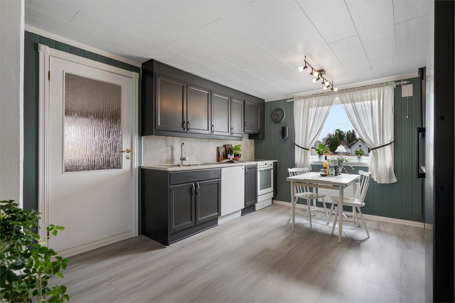 Laminert benkeplate med skyllekum og oppvaskkum med ettgreps armatur, og platekledning over benkeplate.