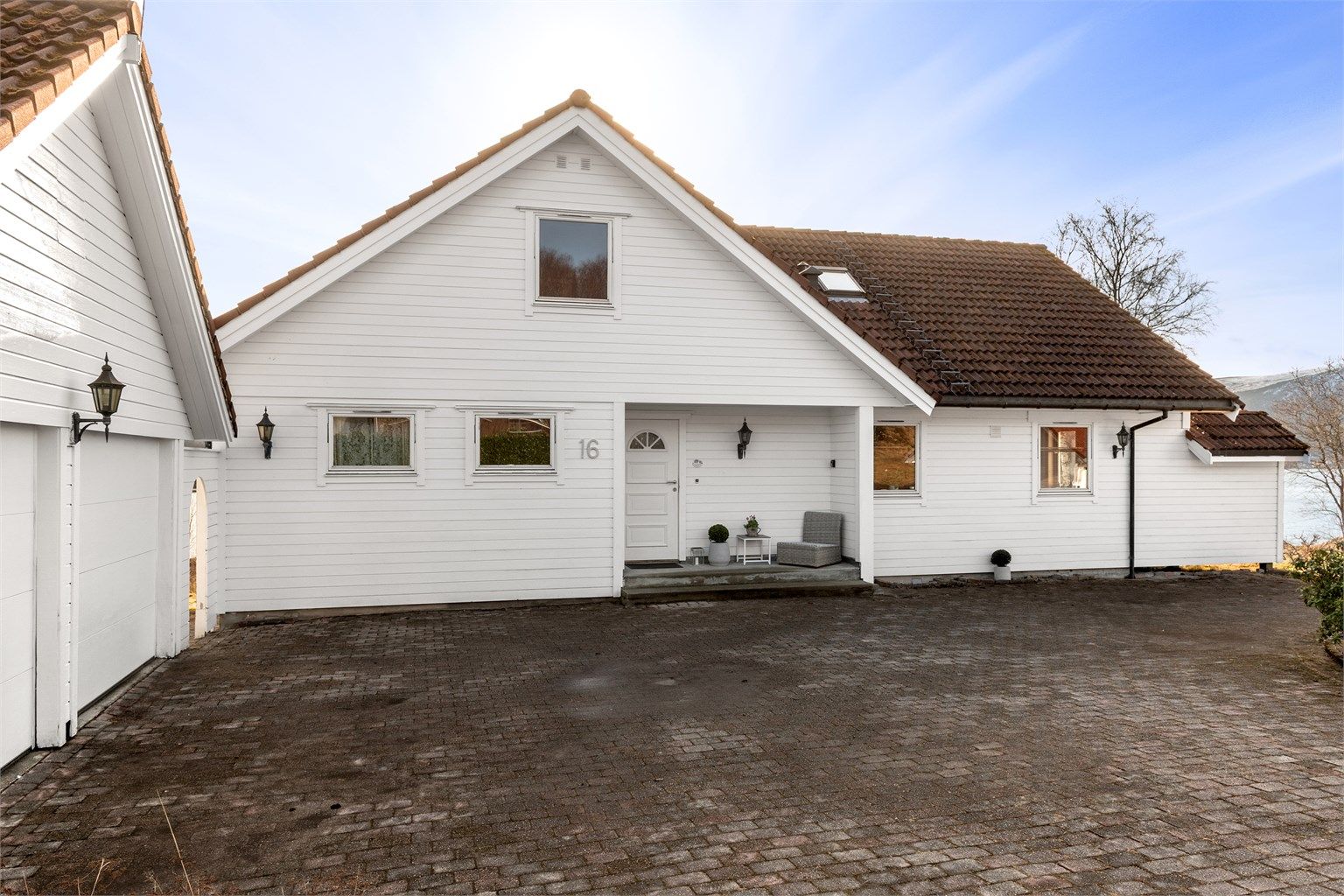 Stor og romslig steinlagt gårdsplass foran garasje med gode parkeringsmuligheter