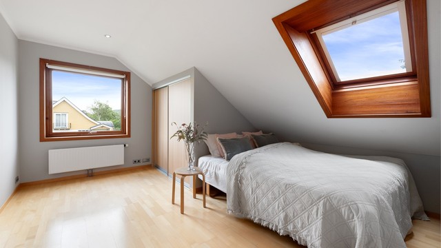 Soverom med overlysvindu, skyvedørsgarderobe og parkettgulv.