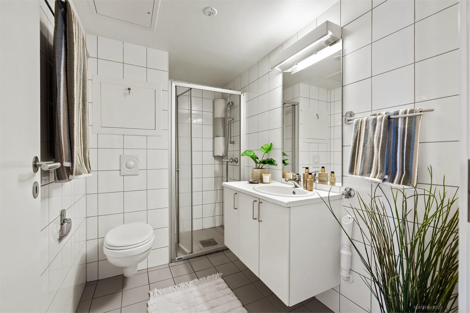 Badet har dusjnisje med innfellbar dusjdør av glass.