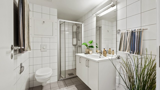 Badet har dusjnisje med innfellbar dusjdør av glass.