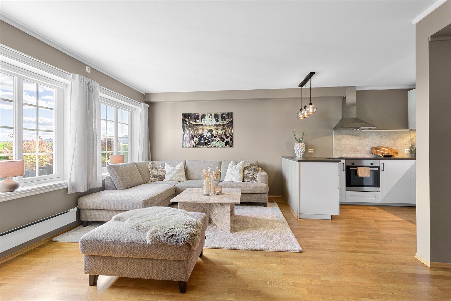 Stuen har store vindusflater mot hagen og plass til en romslig sofagruppe.