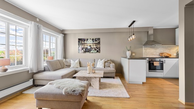 Stuen har store vindusflater mot hagen og plass til en romslig sofagruppe.