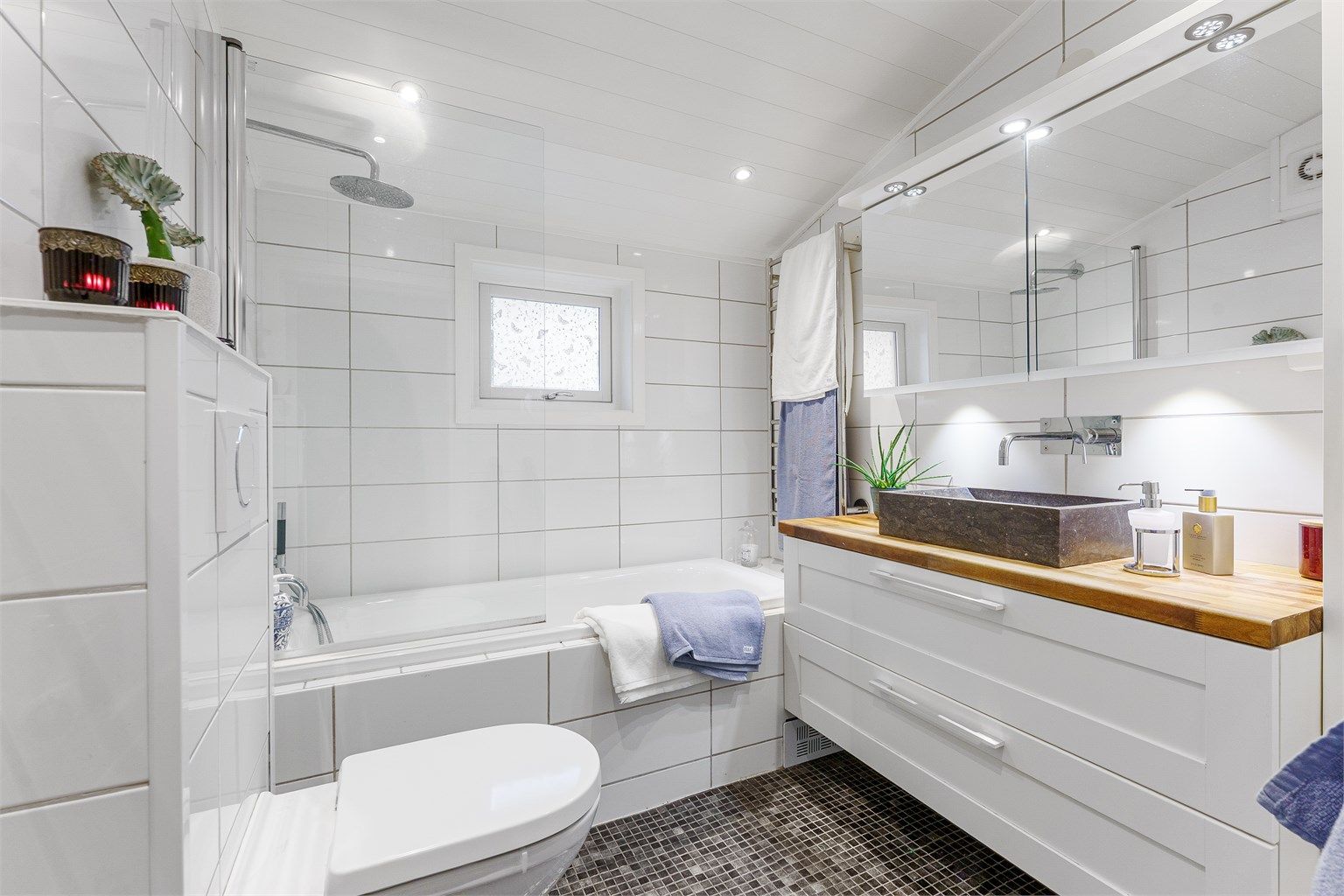 Helflist bad i 2. etasje med badekar og dusjløsning.